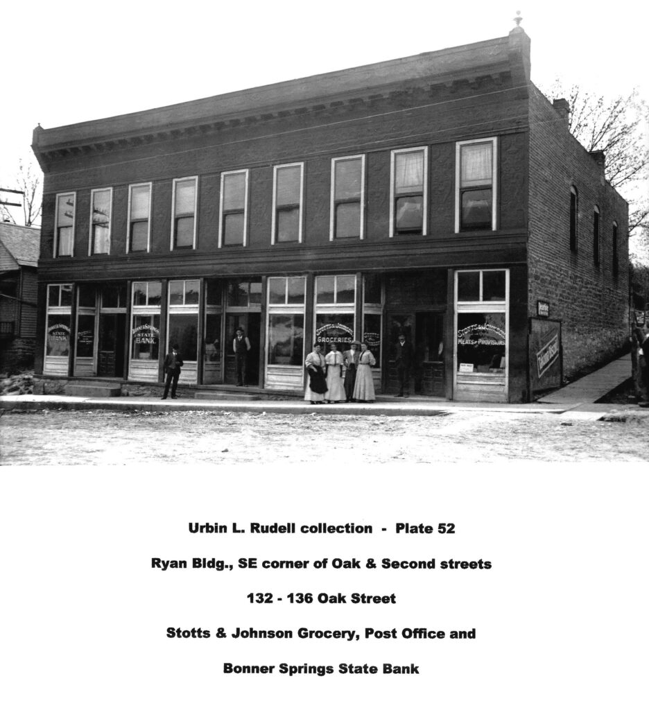Urbin L Rudell Collection plate 52. Ryan Blydg, SE corner of Oak & Second streets. 132 - 136 Oak Street. Stotts & Johnson Grocery, Post Office and Bonner Springs State Bank.